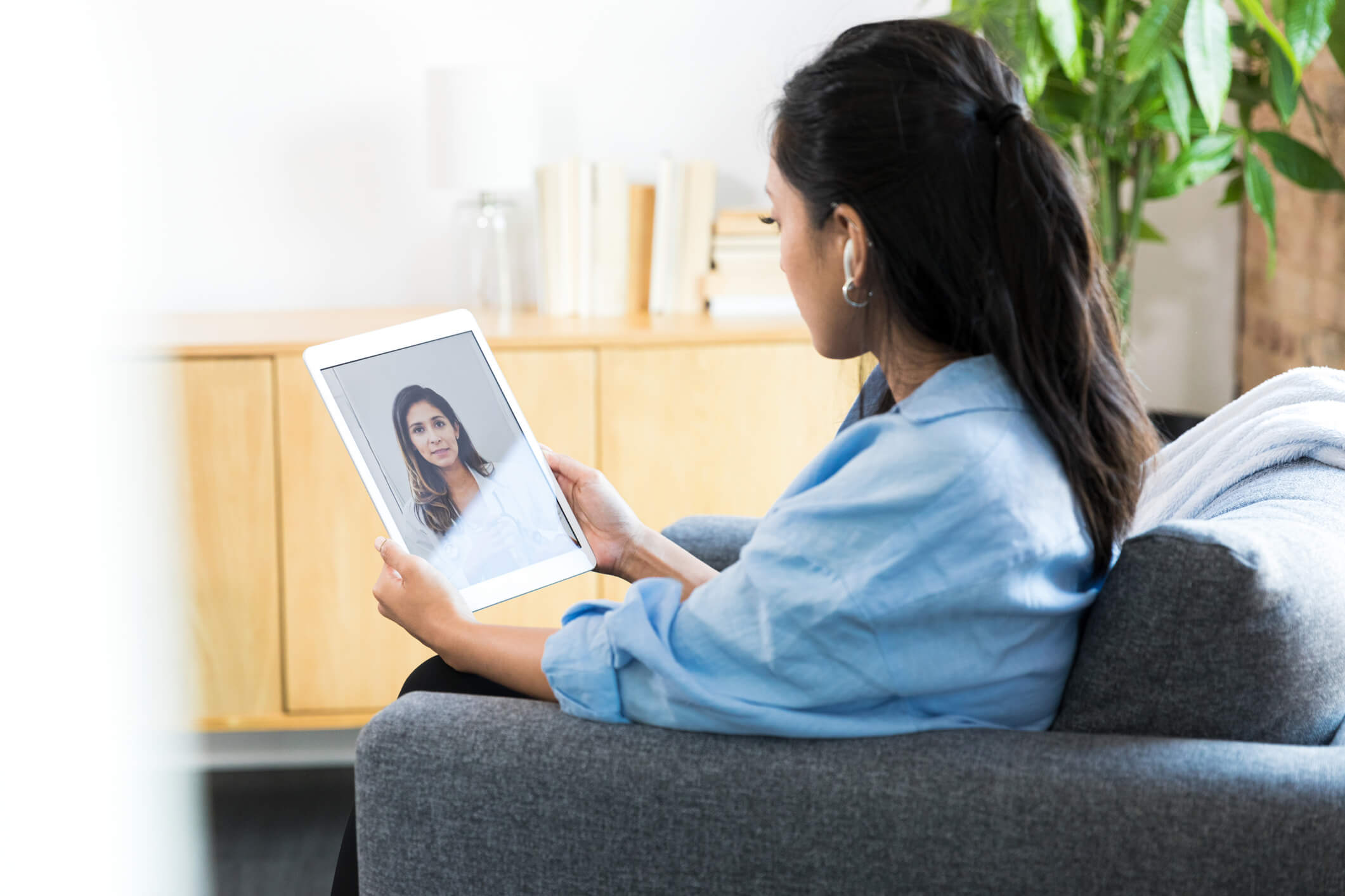Woman video chatting on tablet at home