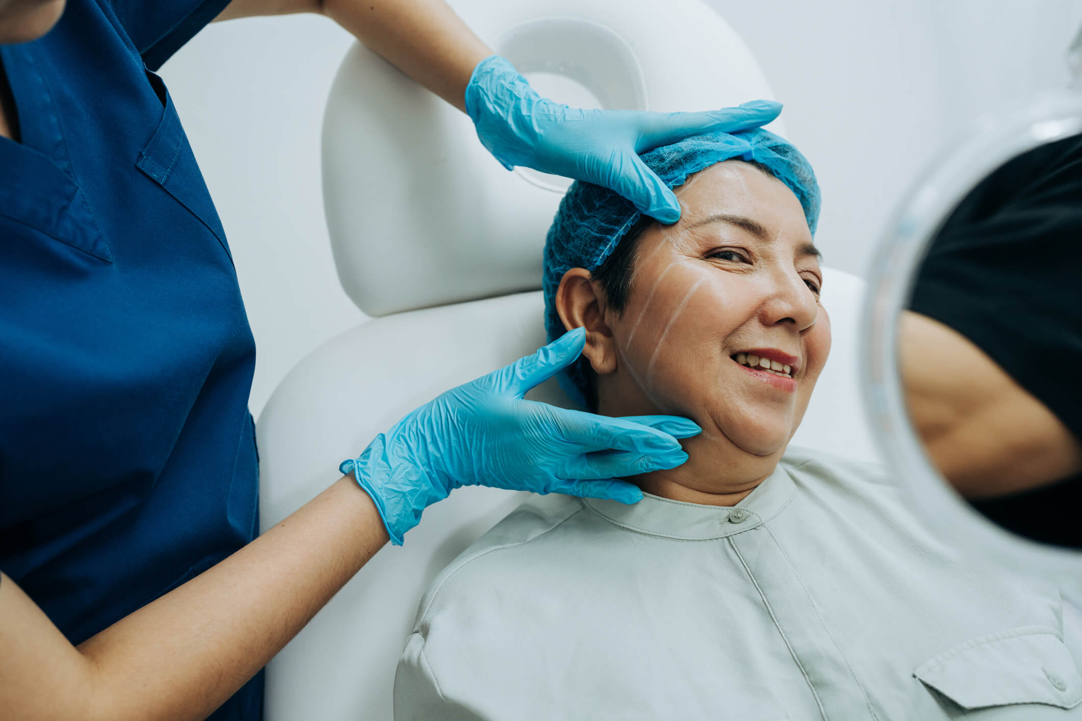 Nurse examining woman's face in clinic