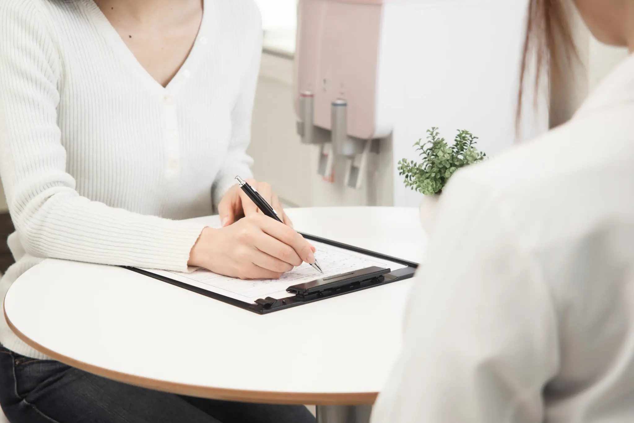 Person filling out form at a table