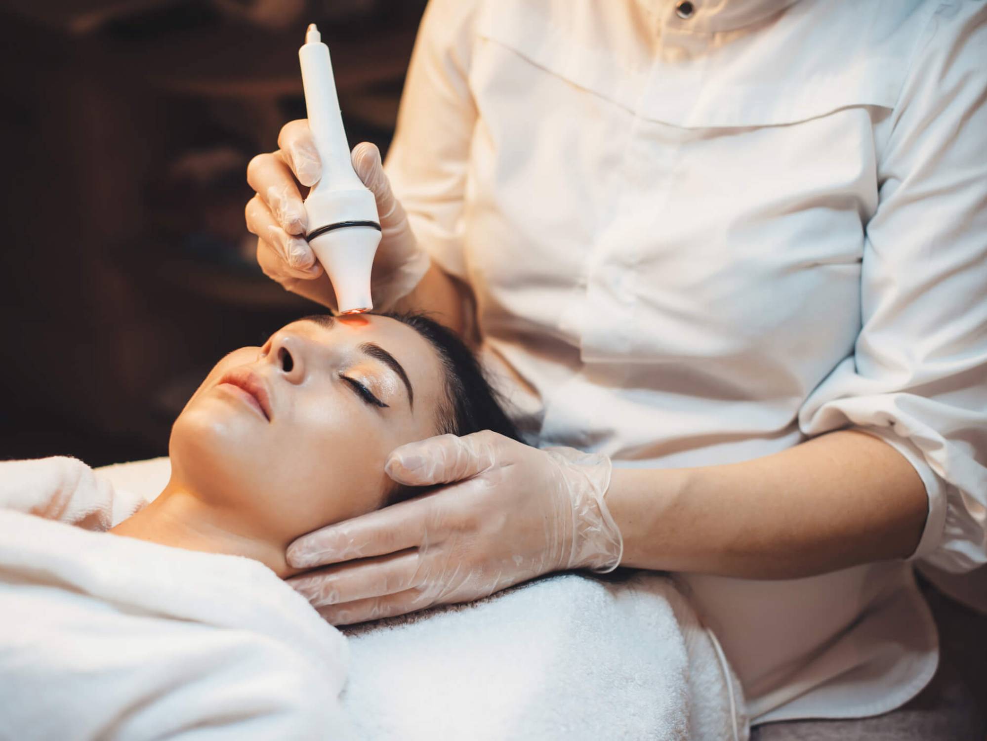 Spa therapist performing facial therapy